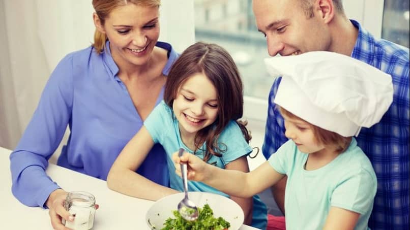 família feliz junta preparando comida saudável