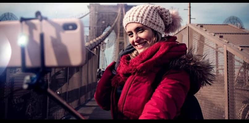 mulher se fotografando com um bastão de selfie