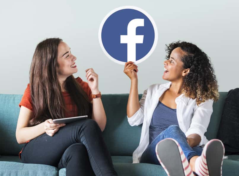 duas mulheres segurando o logotipo do facebook