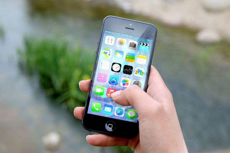 iphone na mão com menu de apps