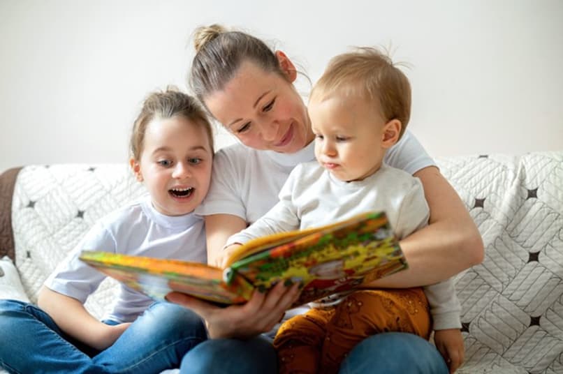 mãe ensina seus filhos a ler
