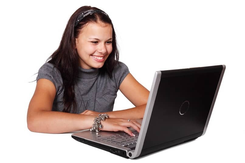 mulher sorri na frente de seu laptop