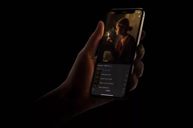 telefone em uma mão com foto escura predefinida do Lightroom Mobile
