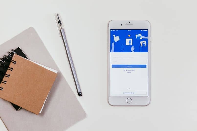 smartphone com aplicativo do Facebook e notebooks