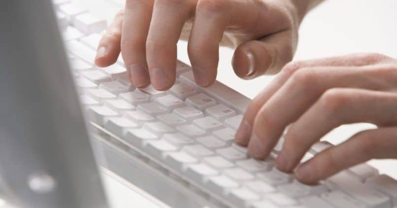 mãos digitando em um teclado mac