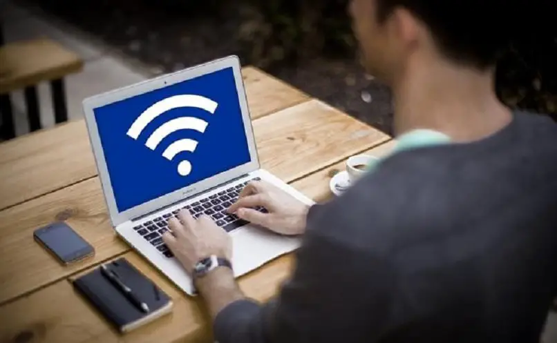 pessoa avaliando o logotipo wifi em seu computador