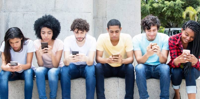 grupo de jovens olhando para seus telefones