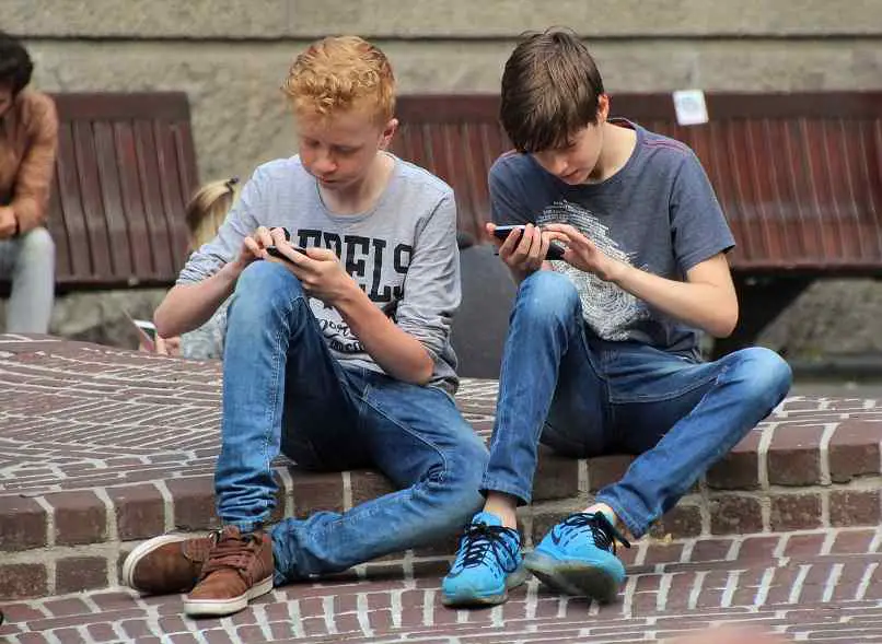 meninos brincando com seu telefone na rua